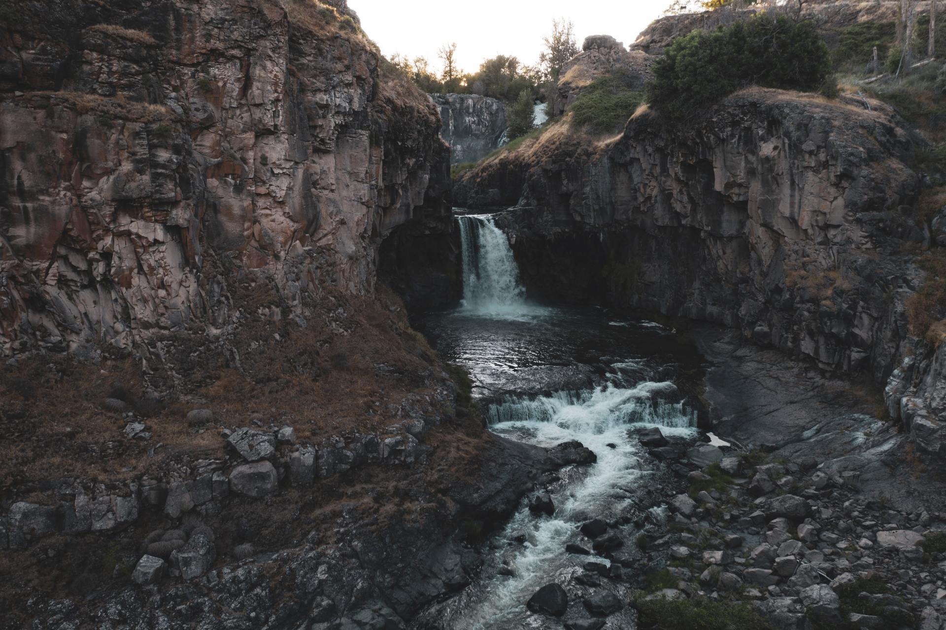 Kleiner Wasserfall, der in der Abenddämmerung durch eine felsige Schlucht fließt