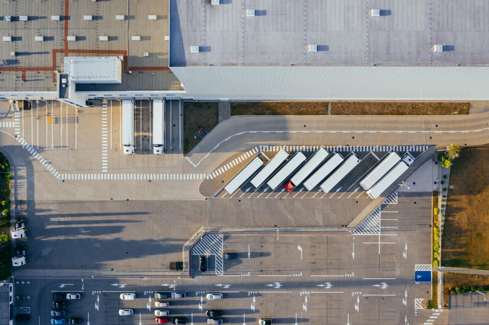 An aerial view of a warehouse with trucks parked in a parking lot.