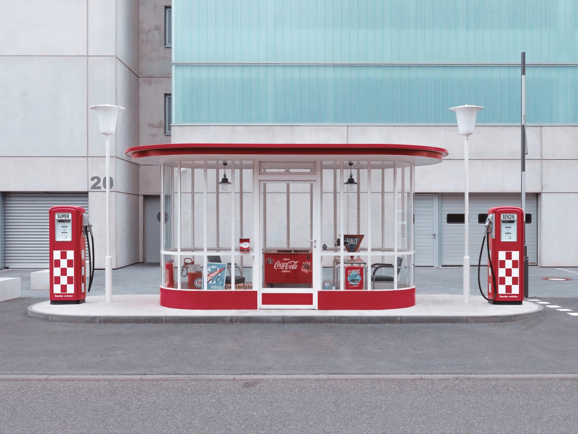Eine rot-weiße Tankstelle vor einem Gebäude