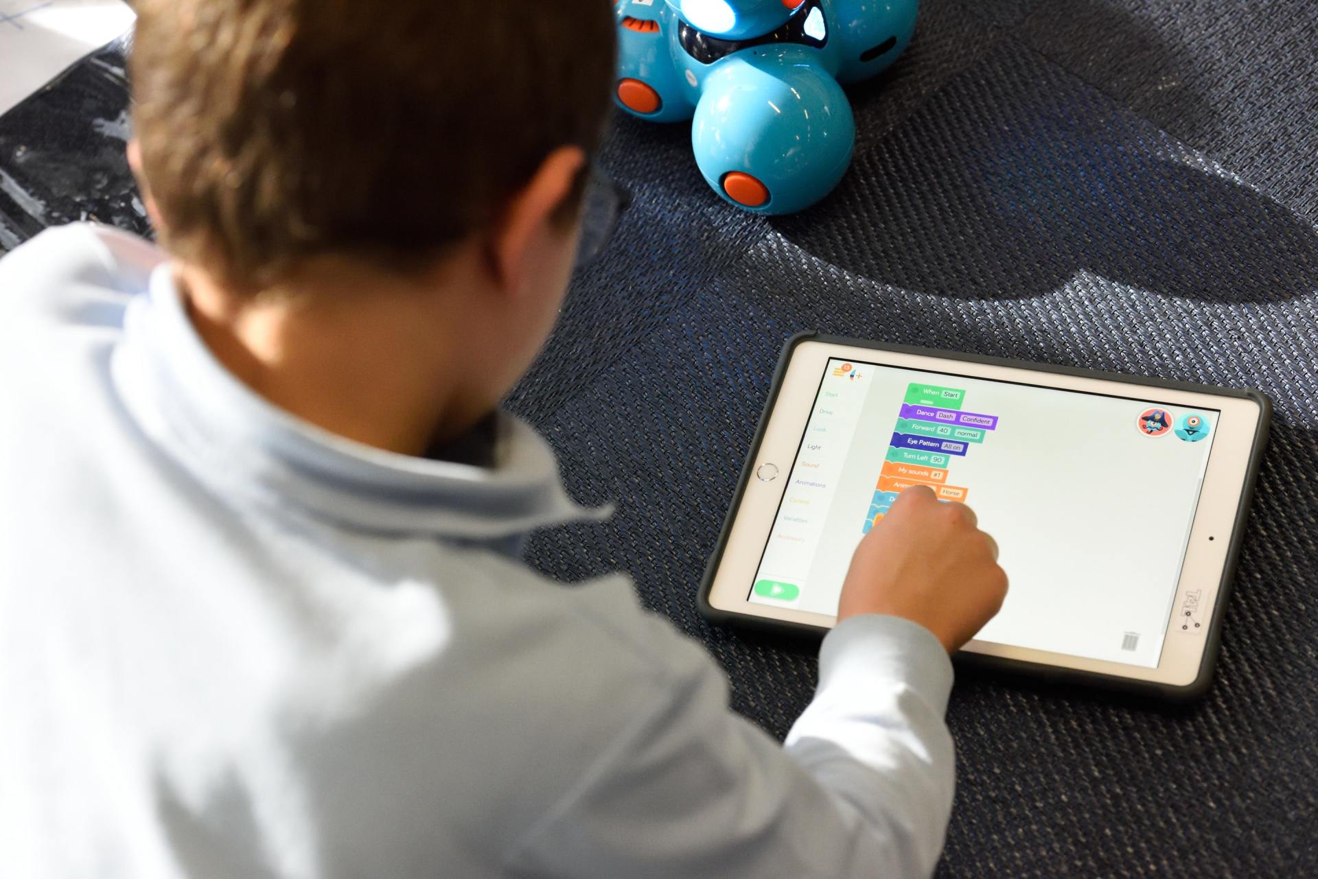 A young boy is playing a game on a tablet.