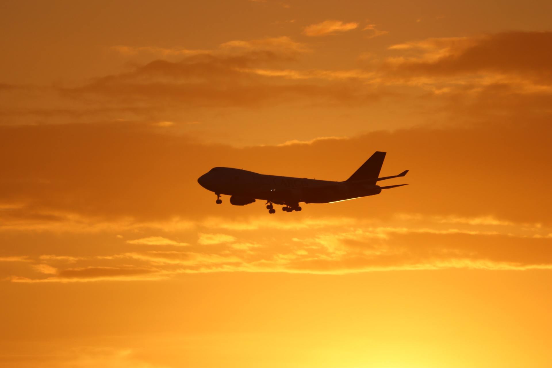 A plane is flying in the sky at sunset