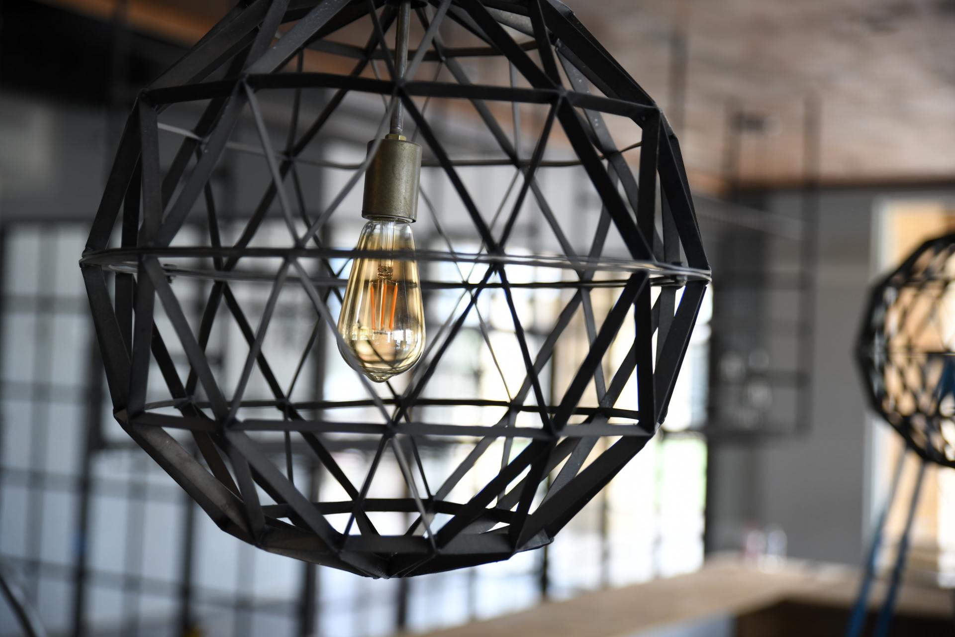 Black round lighting fixture with old-fashion light bulb; The Shade Tree in Houston, TX