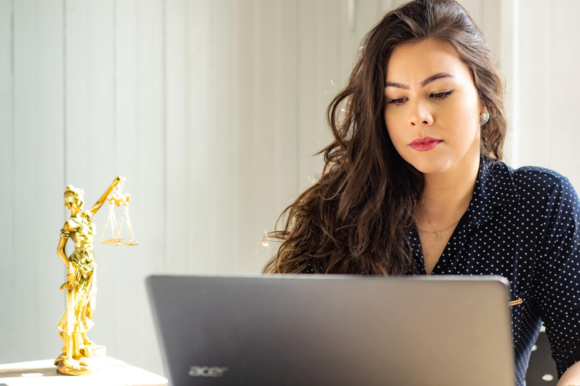 A woman is sitting at a table using a laptop computer.