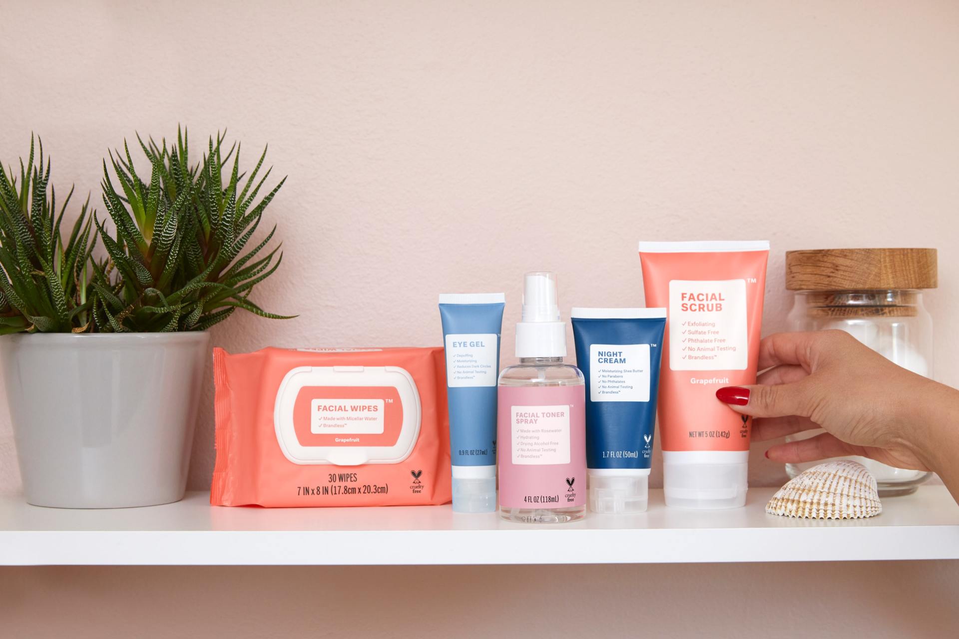 A woman is reaching for a bottle of lotion on a shelf.