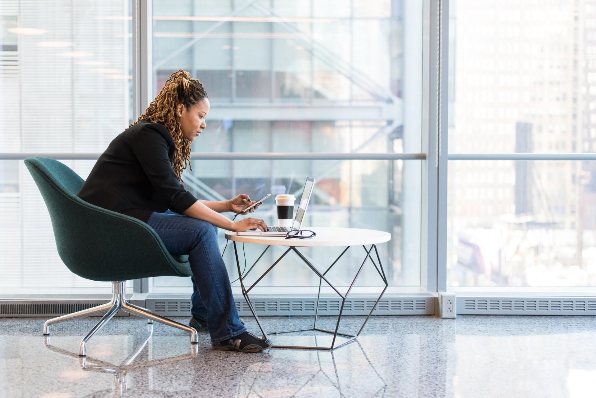 A woman is sitting at a table looking at her phone
