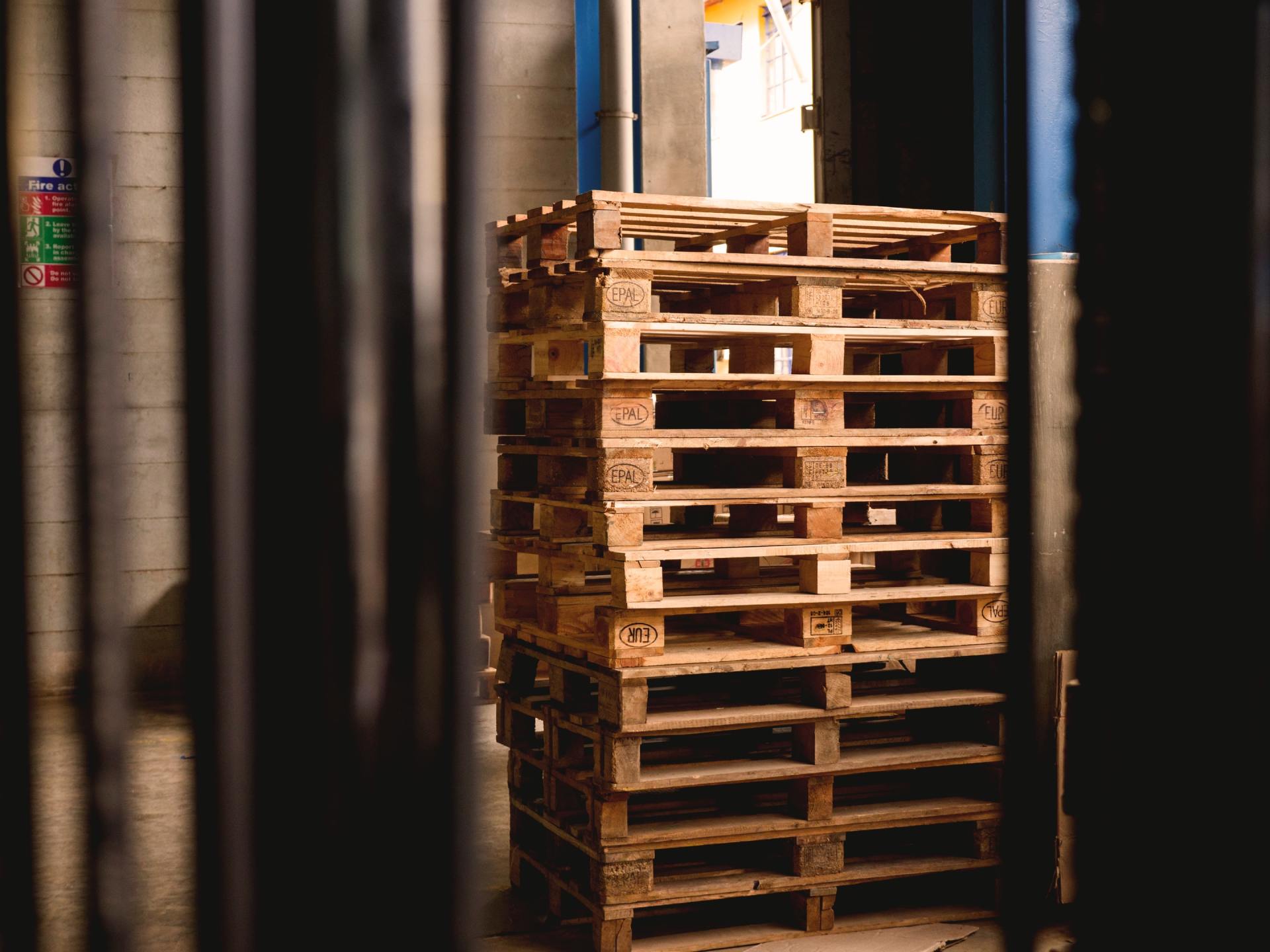 A stack of wooden pallets sitting on top of each other in a warehouse.