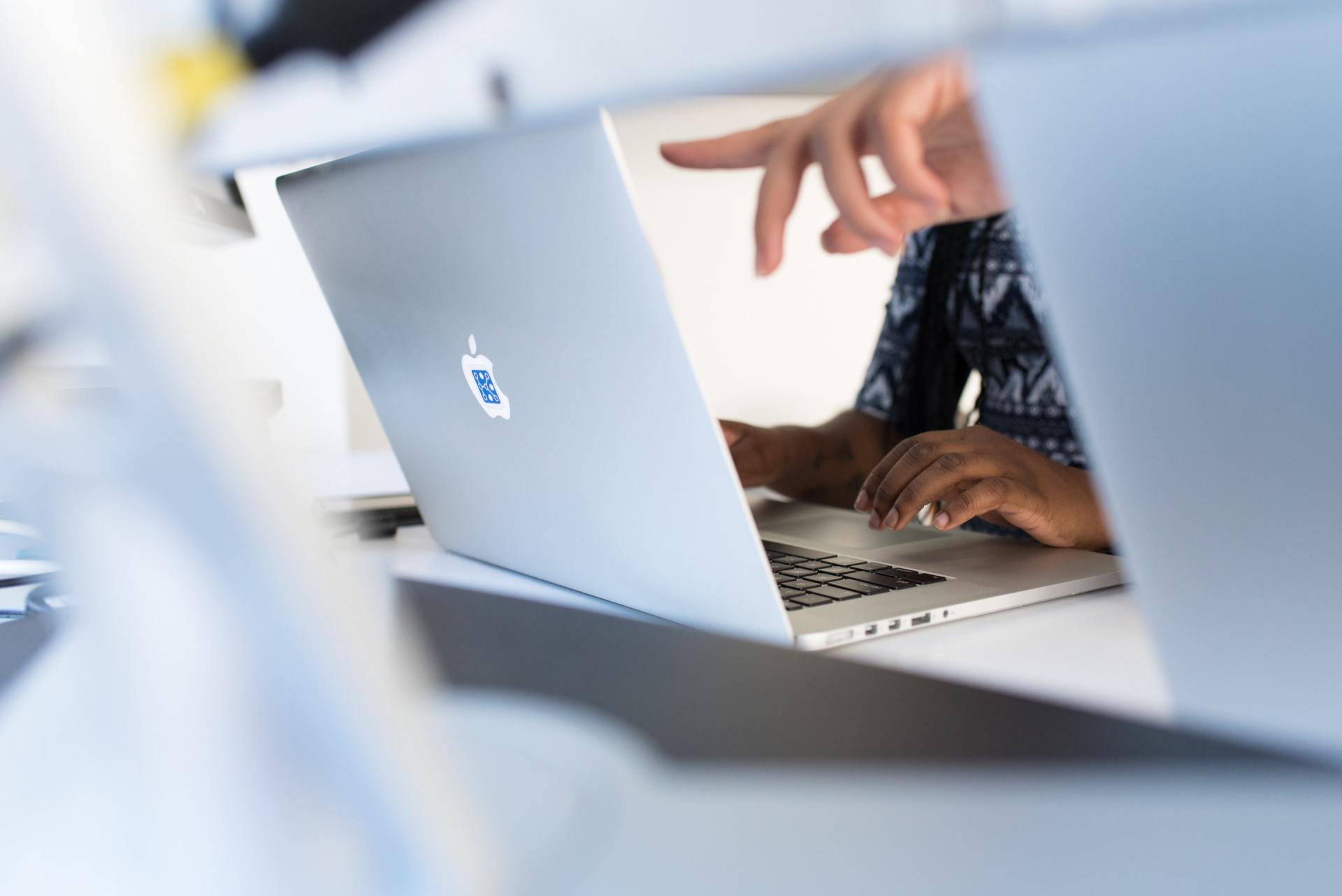 A person is typing on an apple laptop computer.