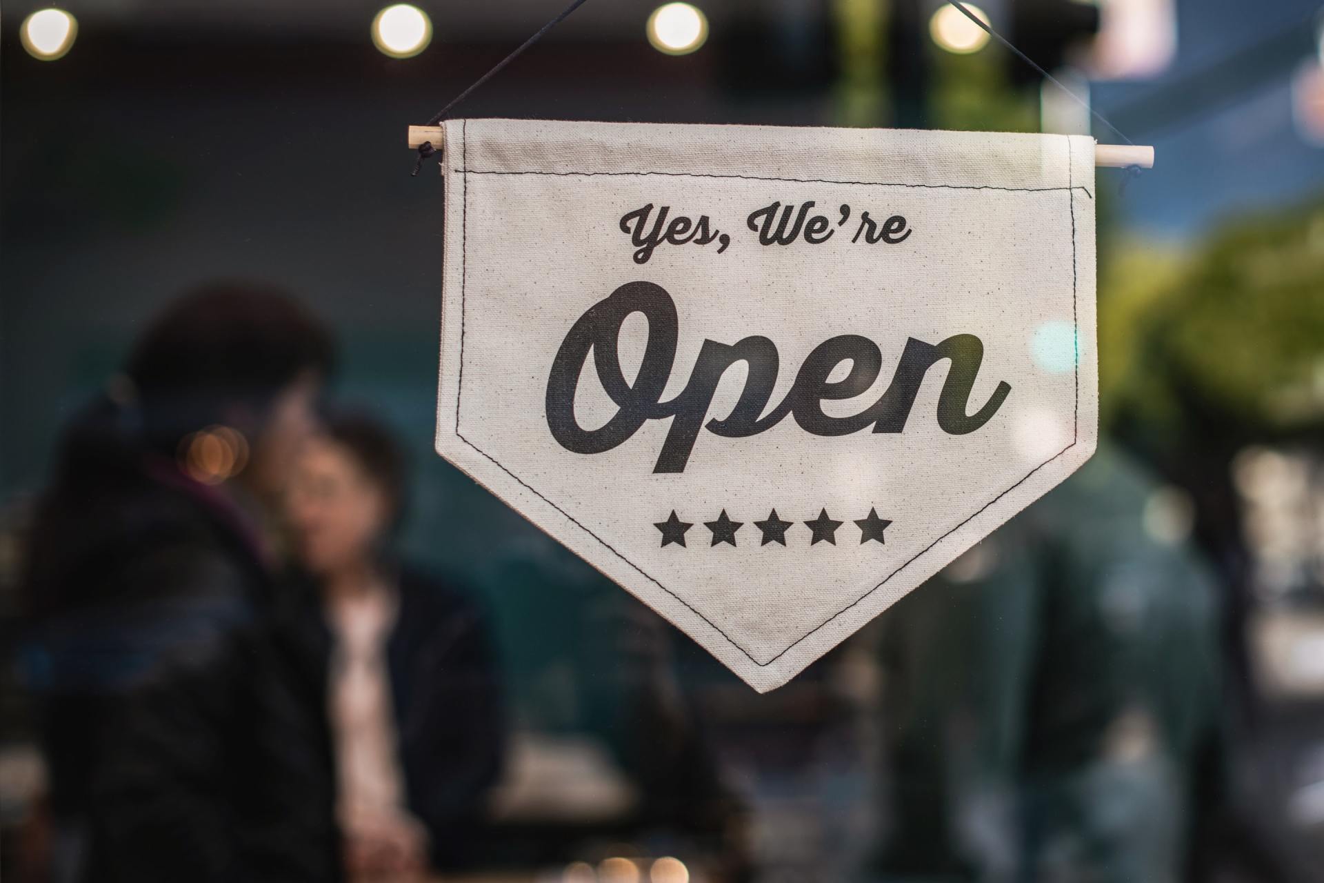 A sign that says `` yes , we 're open '' is hanging in a window.
