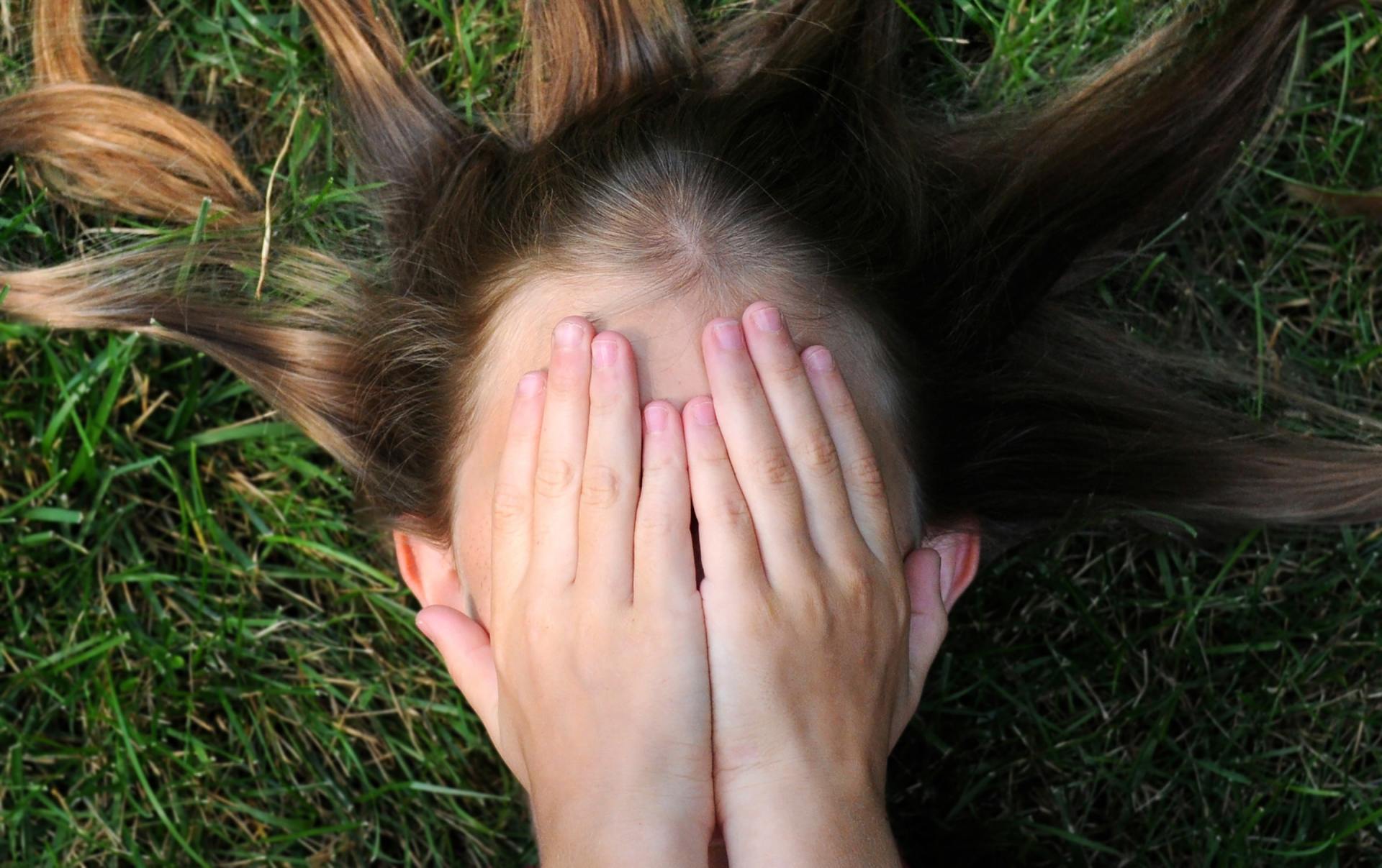 head being covered by hands so as not to see