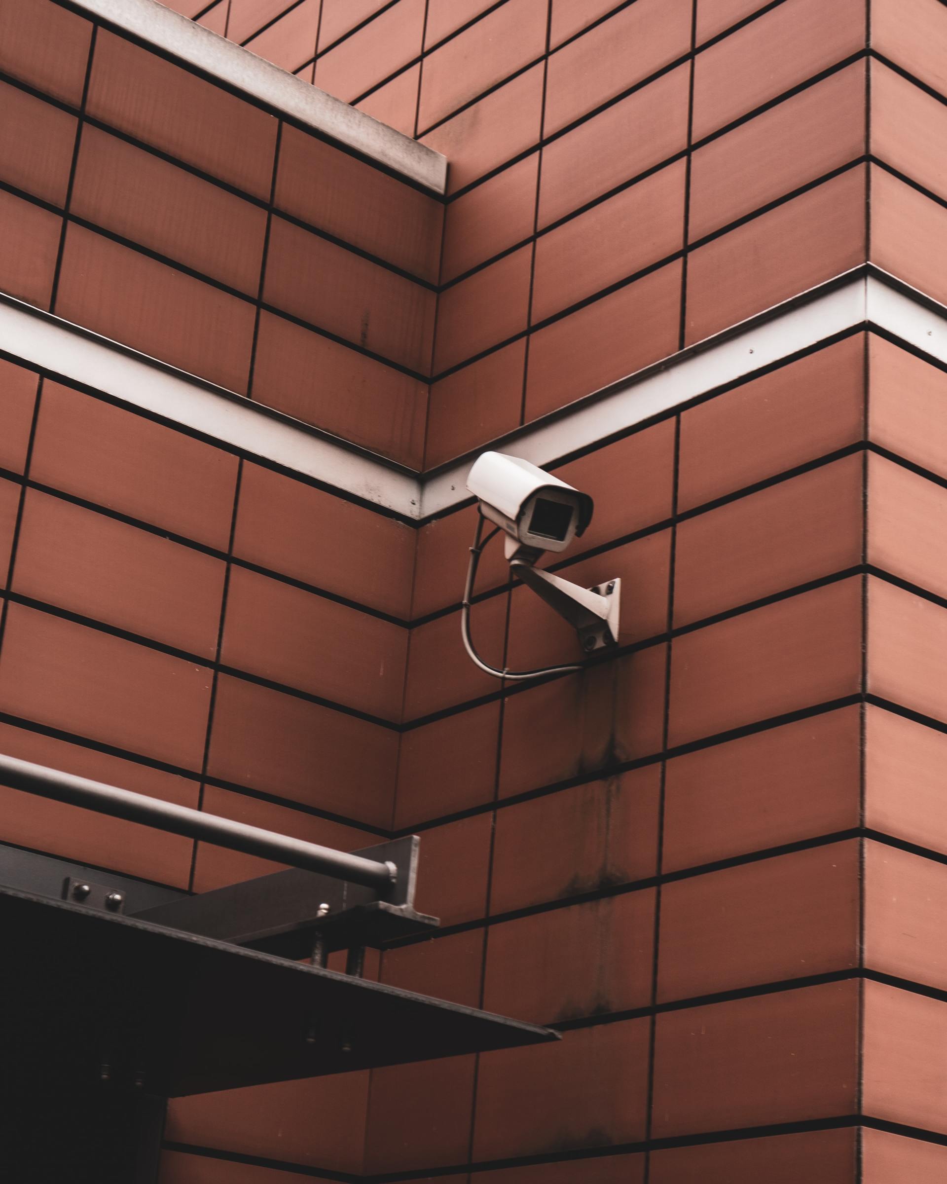 A security camera mounted on the side of a brick building