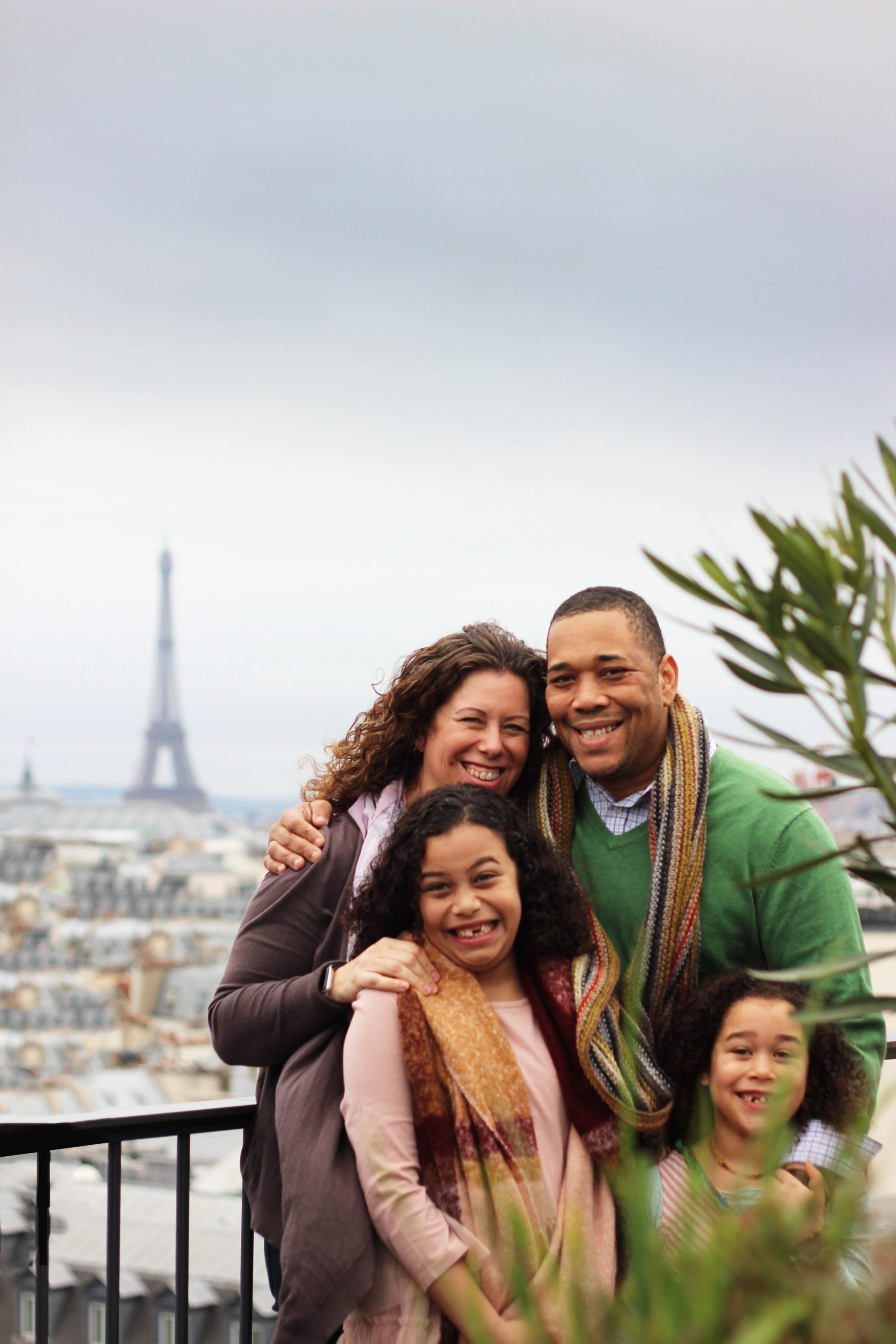A family is posing for a picture in front of the eiffel tower in paris.