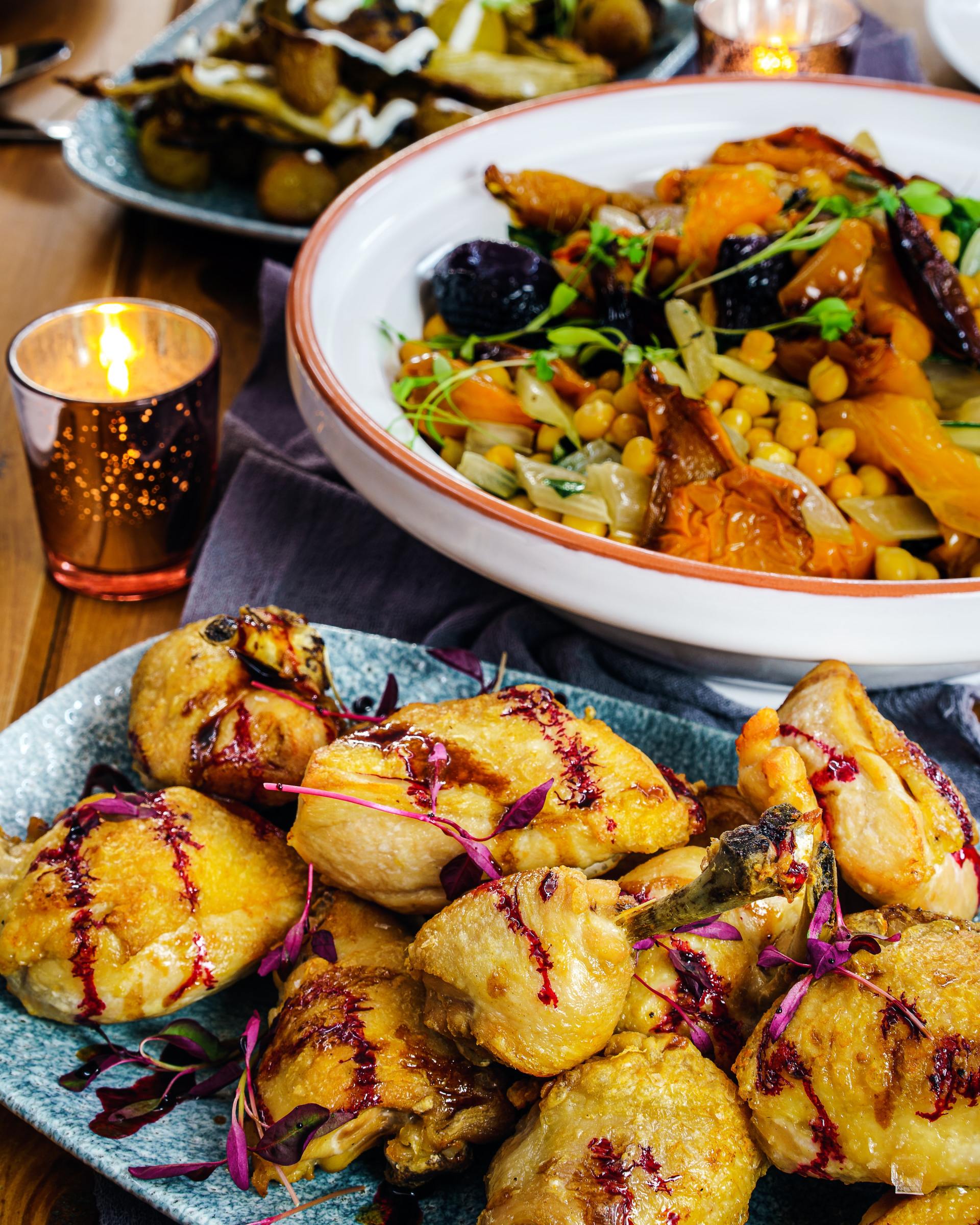 A table topped with plates of food and a candle.