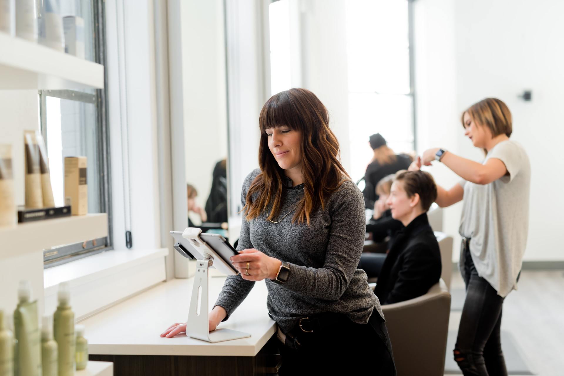 small business owner hair stylist looking at her phone