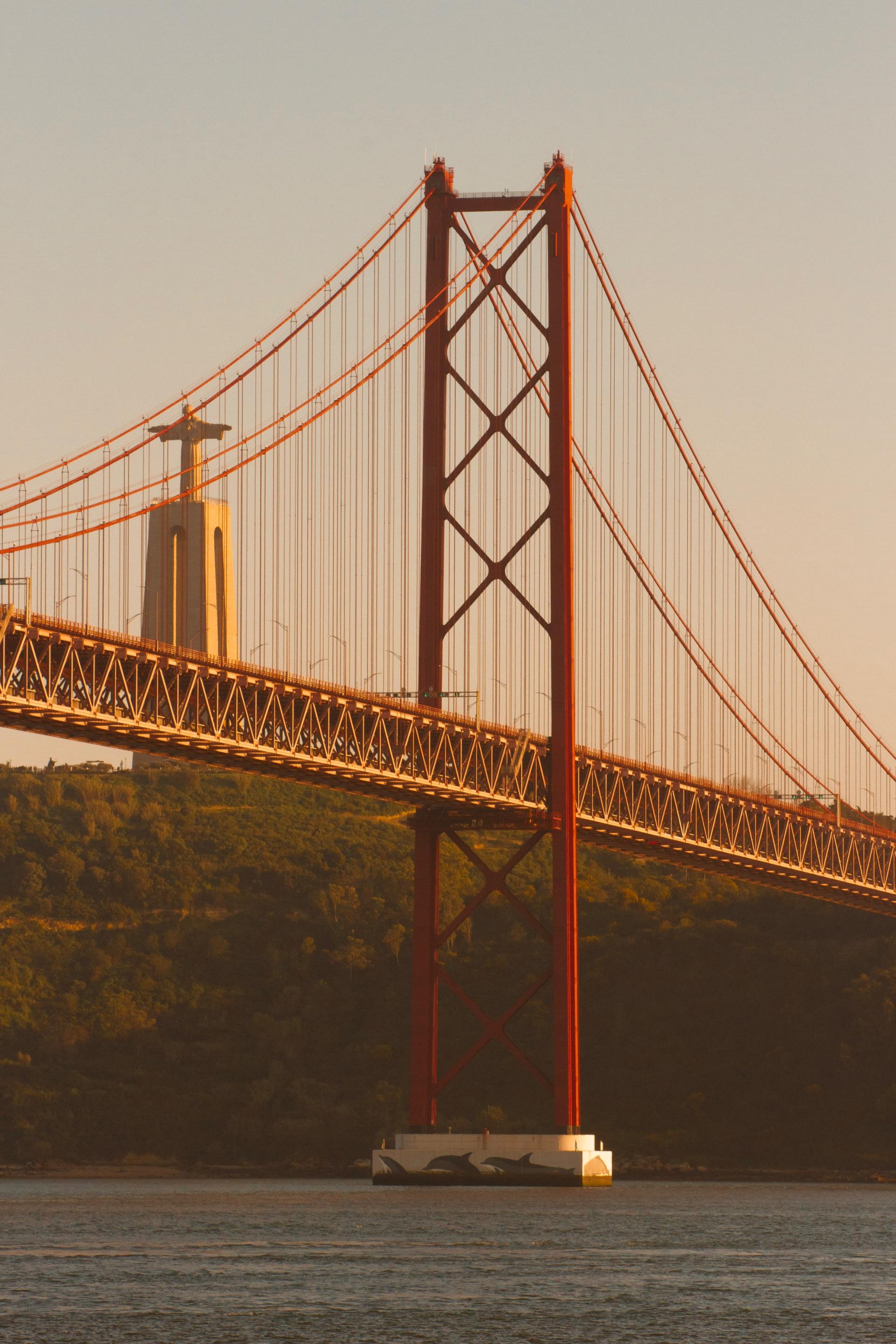 Uma ponte vermelha e dourada sobre um corpo de água