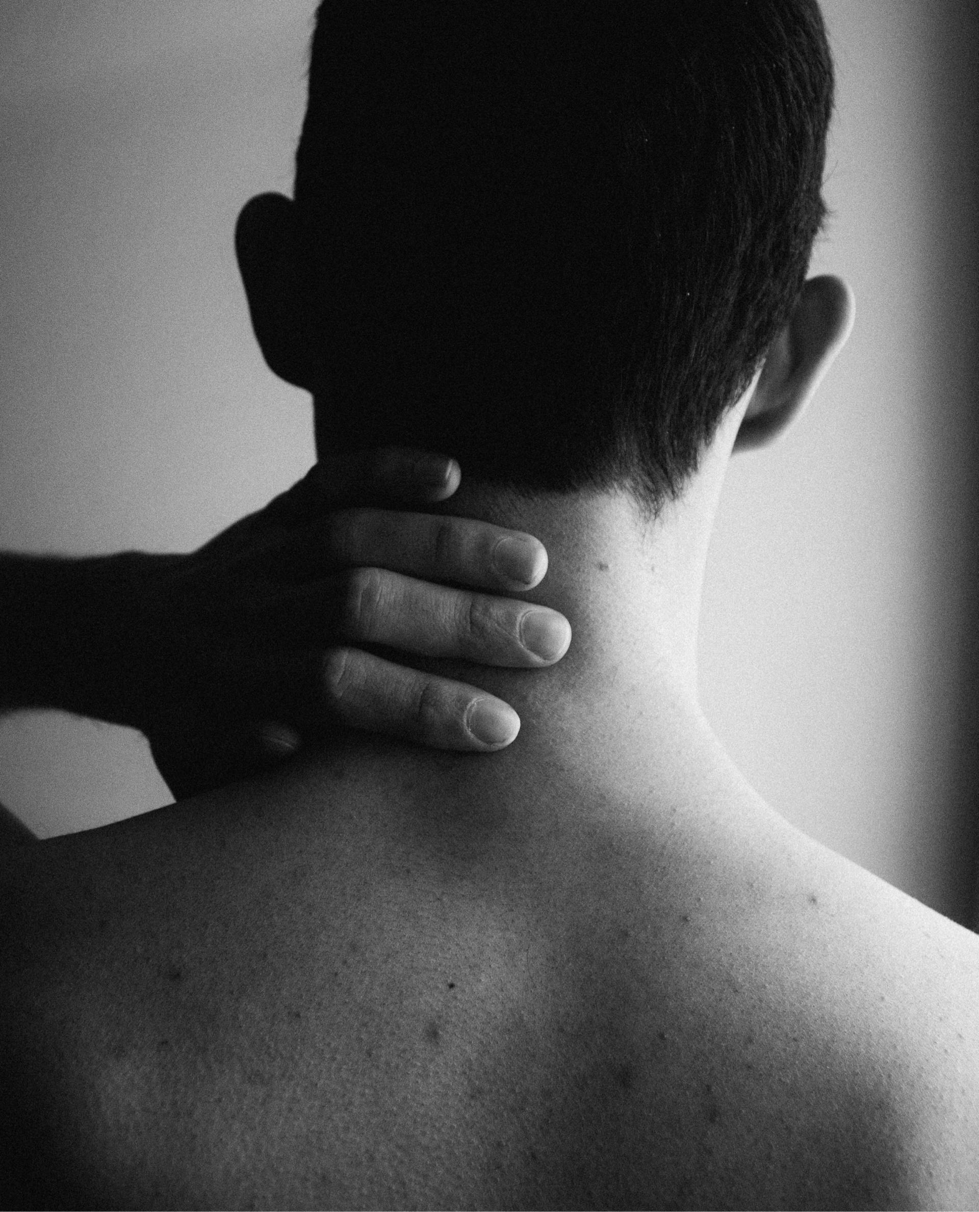 A person is holding a man 's neck in a black and white photo.
