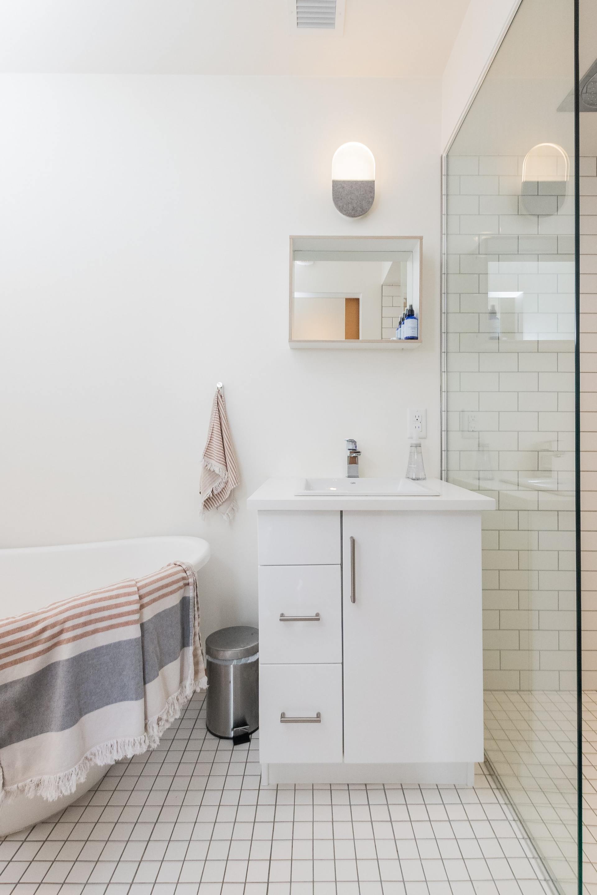 A bathroom with a bathtub , sink , mirror and walk in shower.