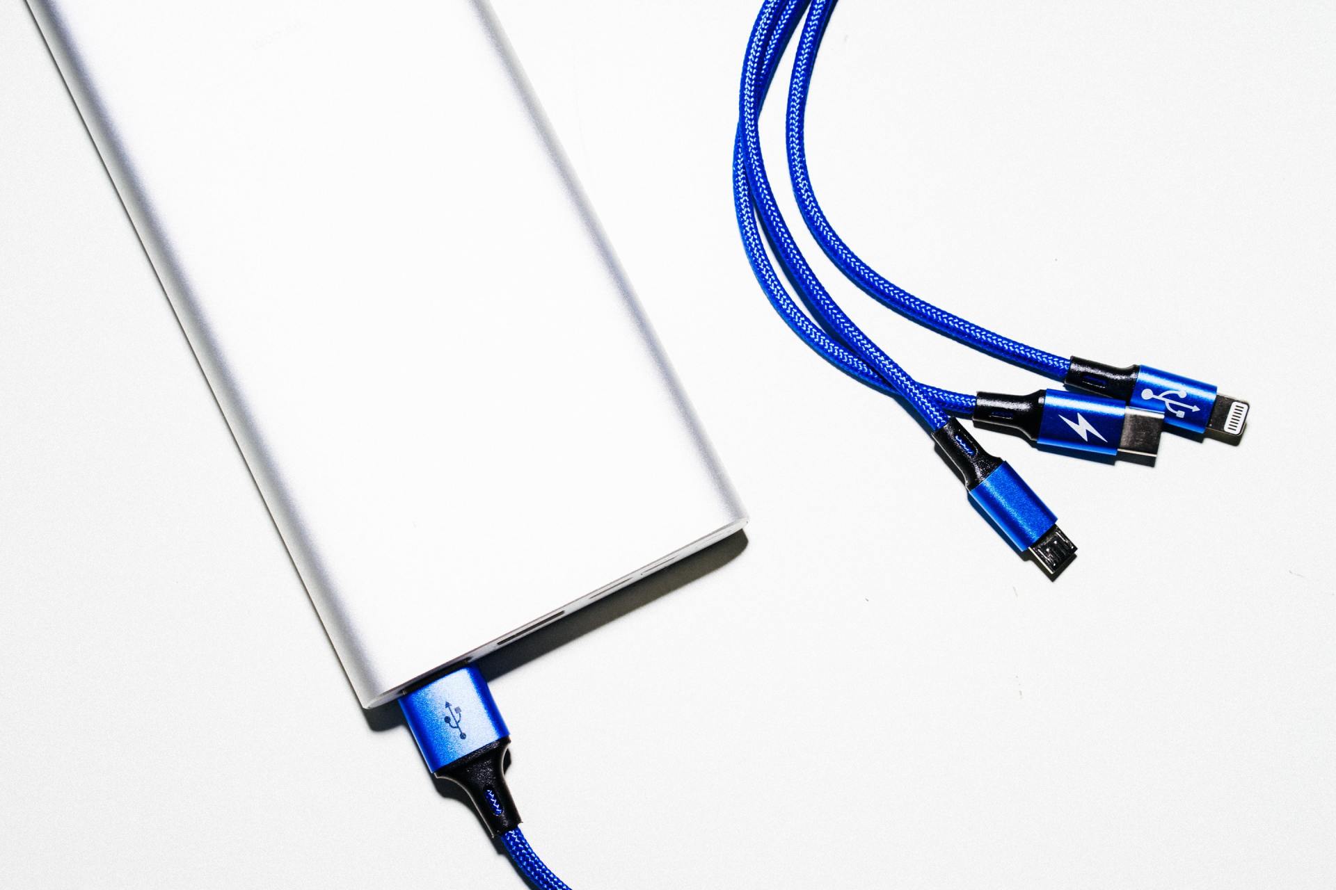 A silver power bank with three blue cables attached to it.