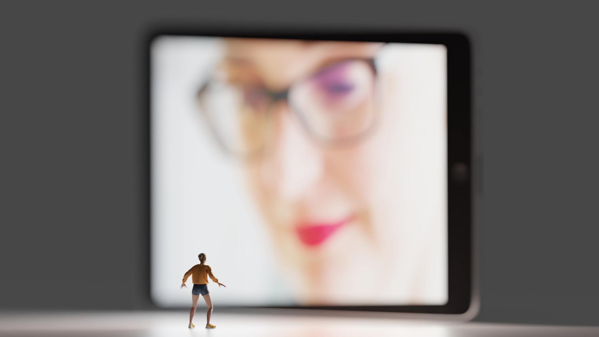 A miniature man is standing in front of a tablet with a woman 's face on it.
