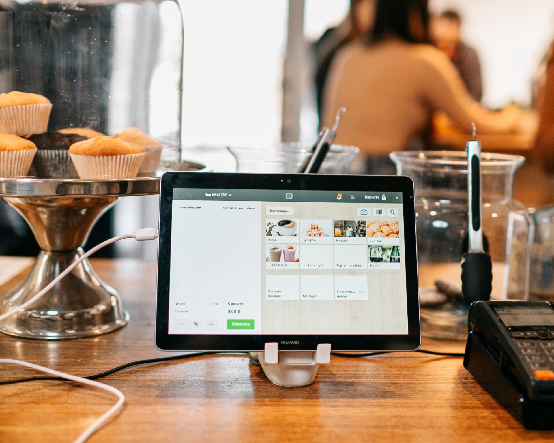 A tablet is sitting on a wooden table in a restaurant.