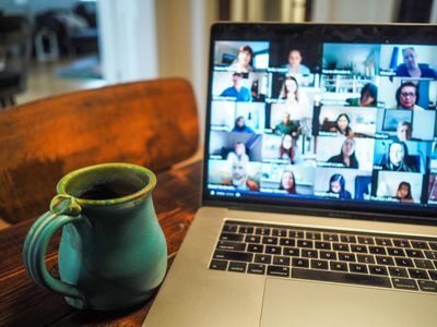 A virtual funeral service being participated in via zoom on a laptop computer.