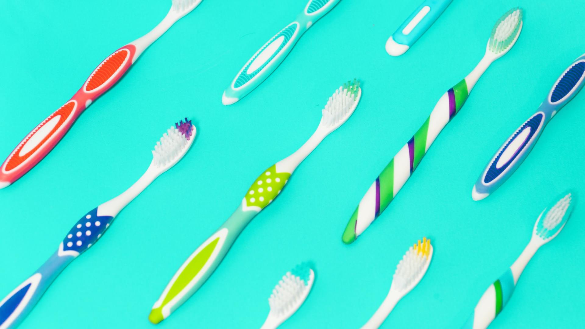 There are many different types of toothbrushes on a blue background.