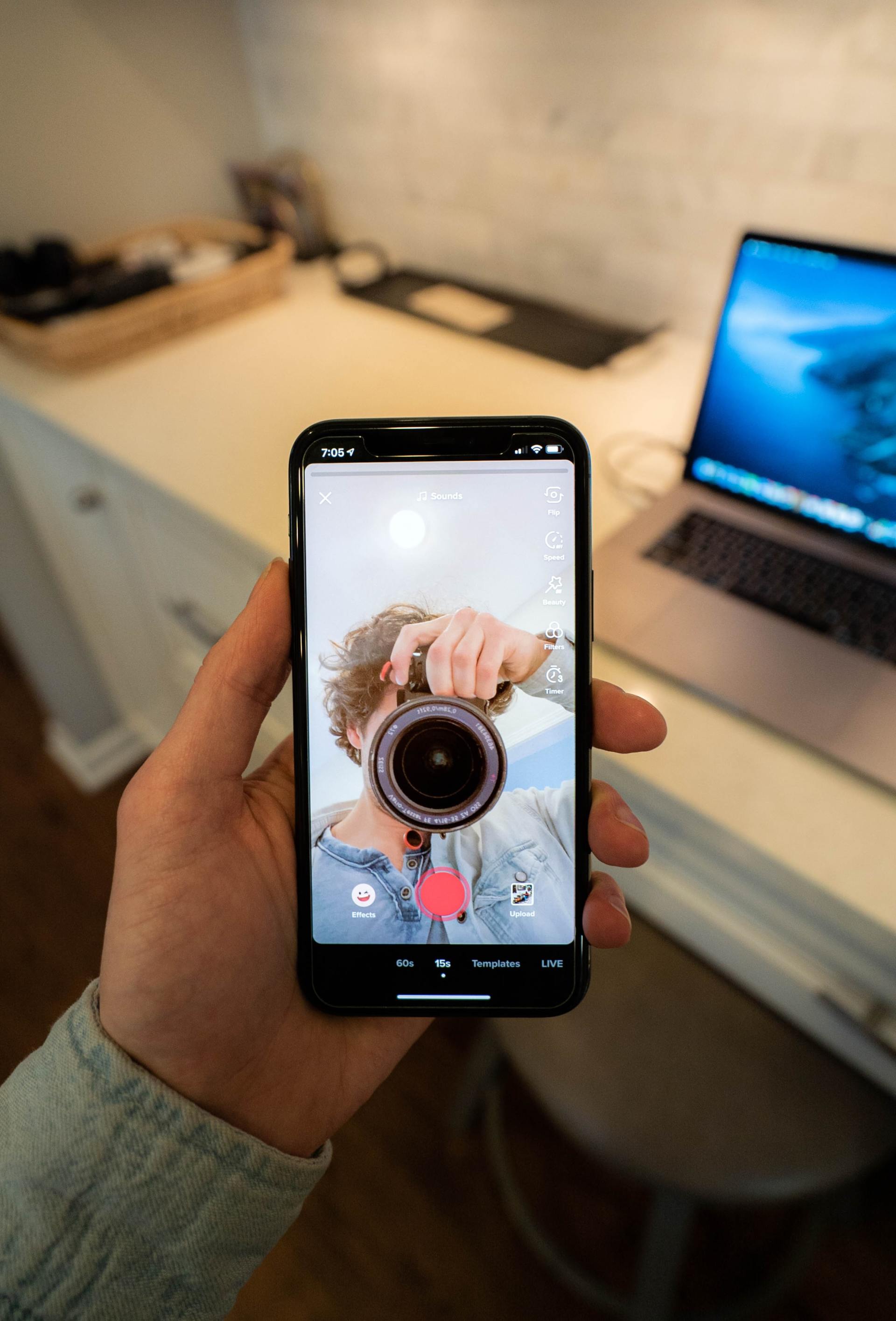 A person is taking a picture of themselves with a camera on their phone
