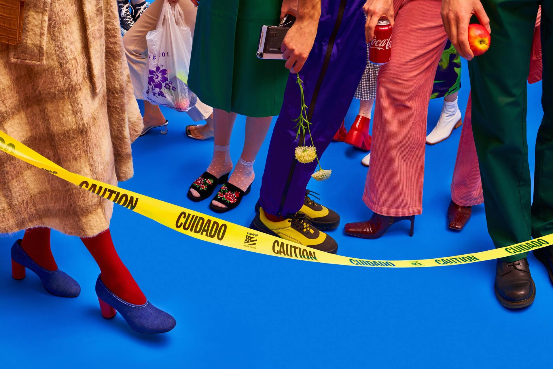 A group of people standing next to a caution tape.