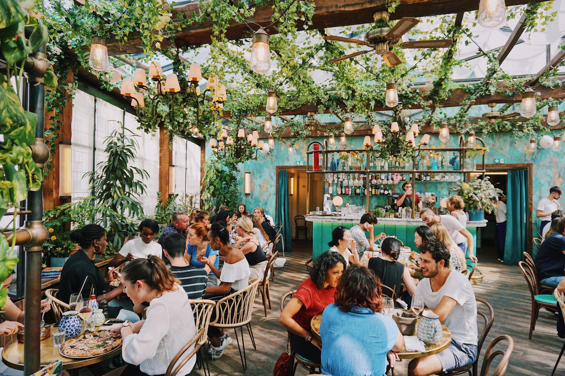 A group of people are sitting at tables in a restaurant.
