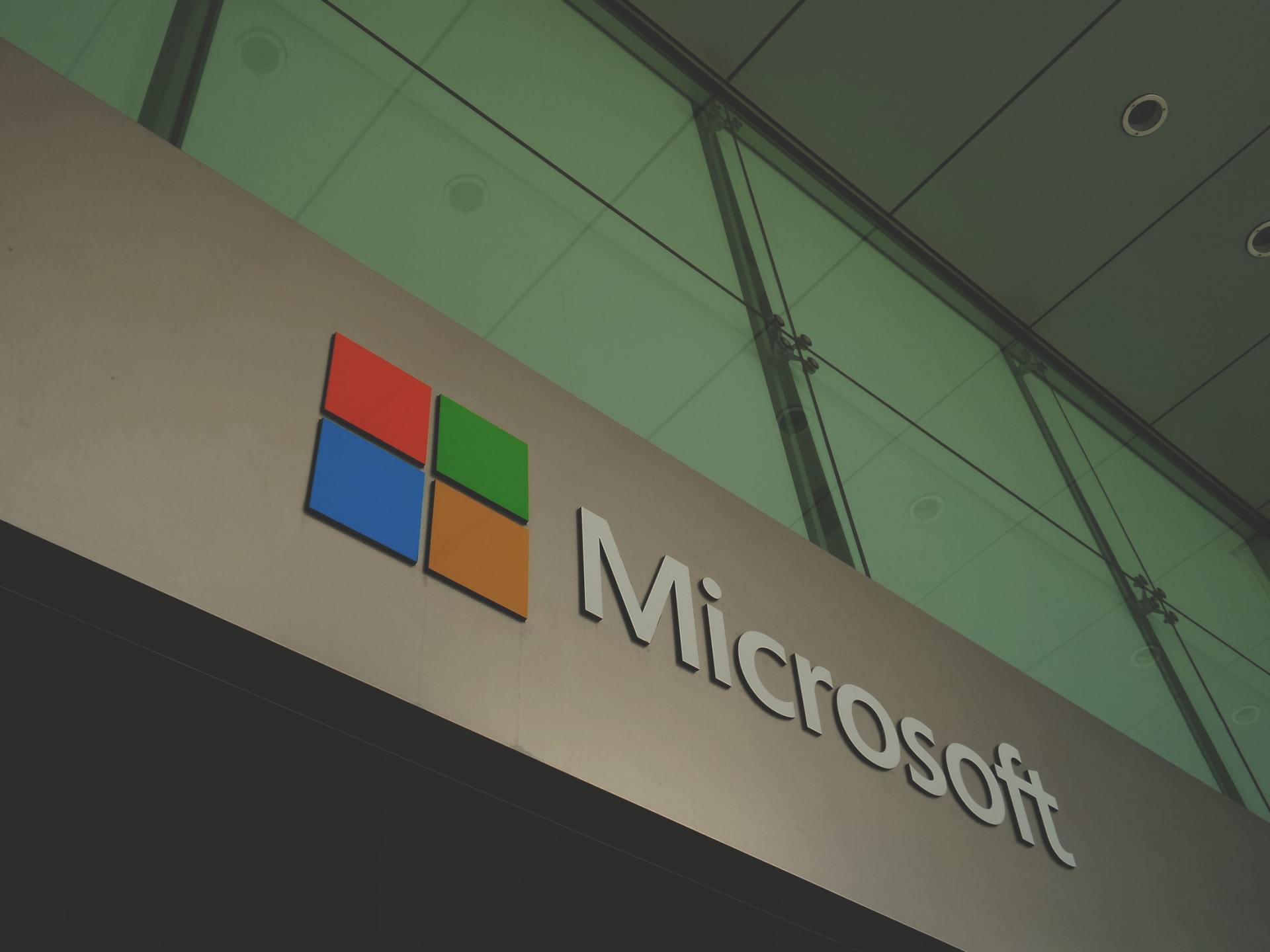 A sign that says microsoft on it in front of a glass wall