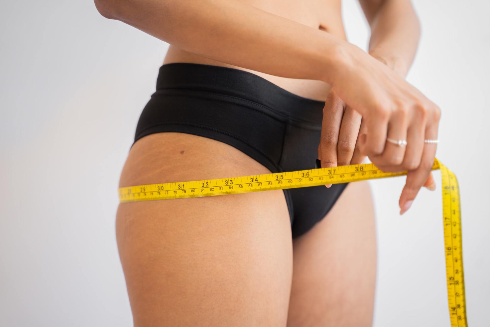 Female_against_gray_wall_with_measuring_tape