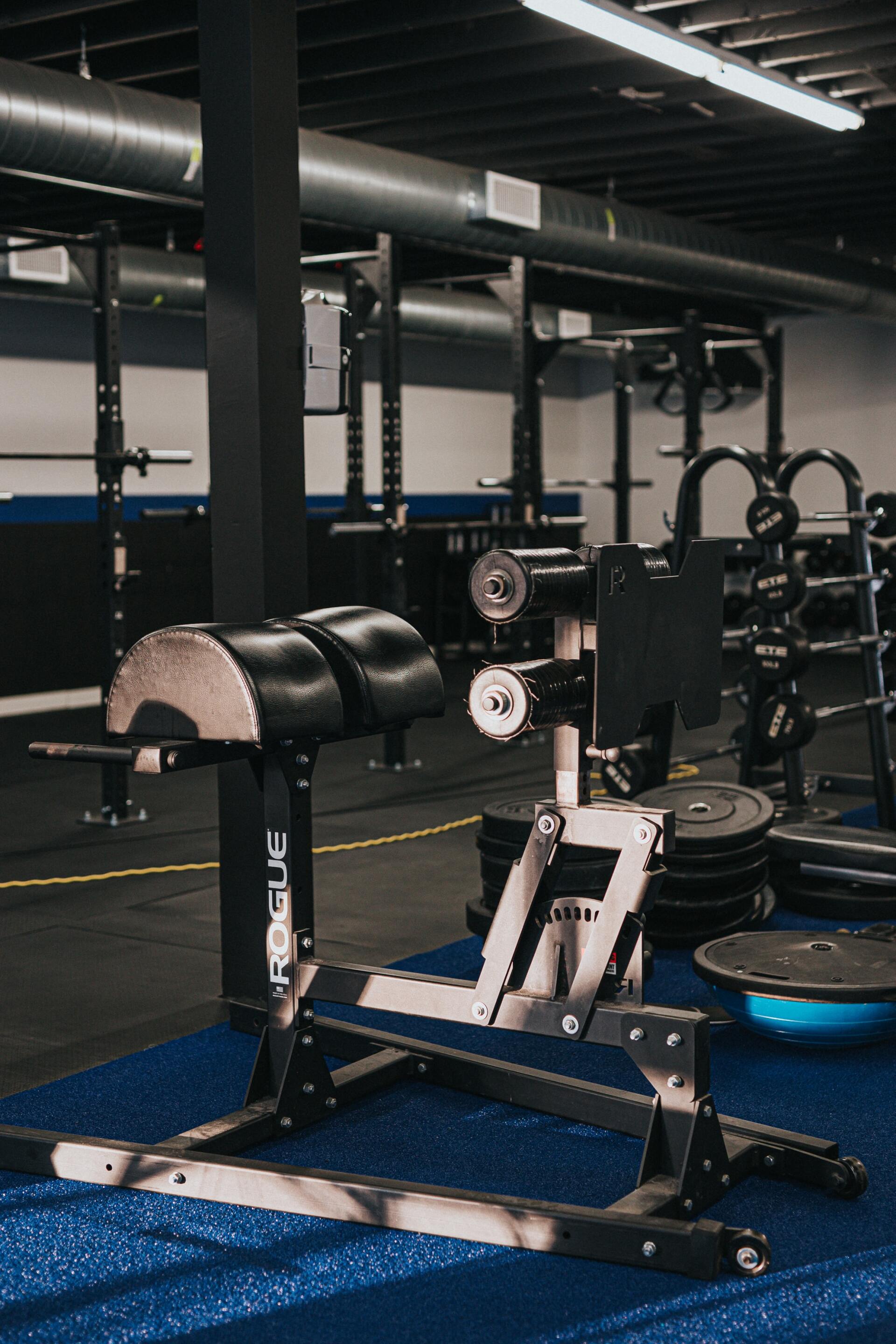 A gym with a lot of exercise equipment on the floor.