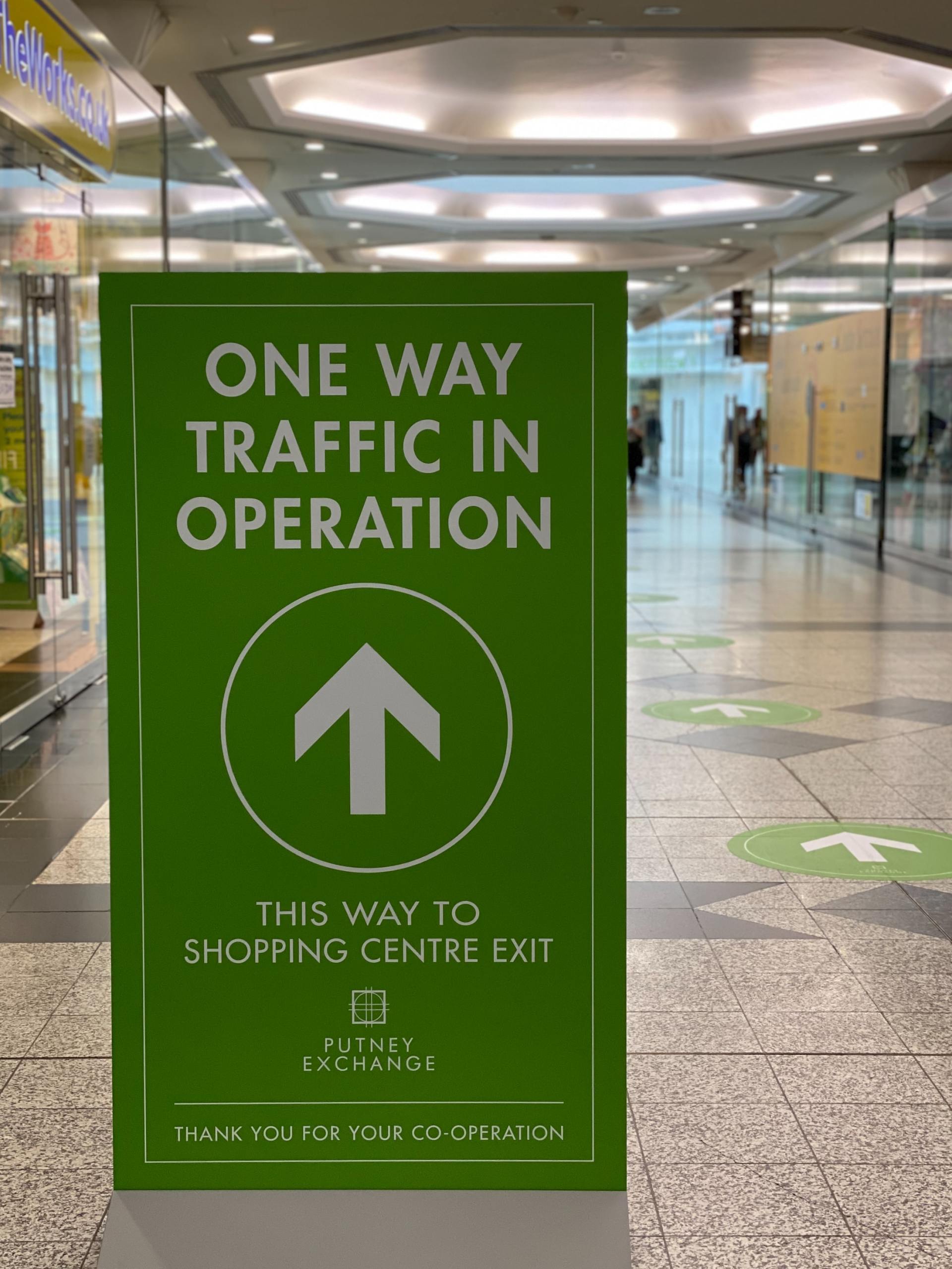 A green sign that says one way traffic in operation