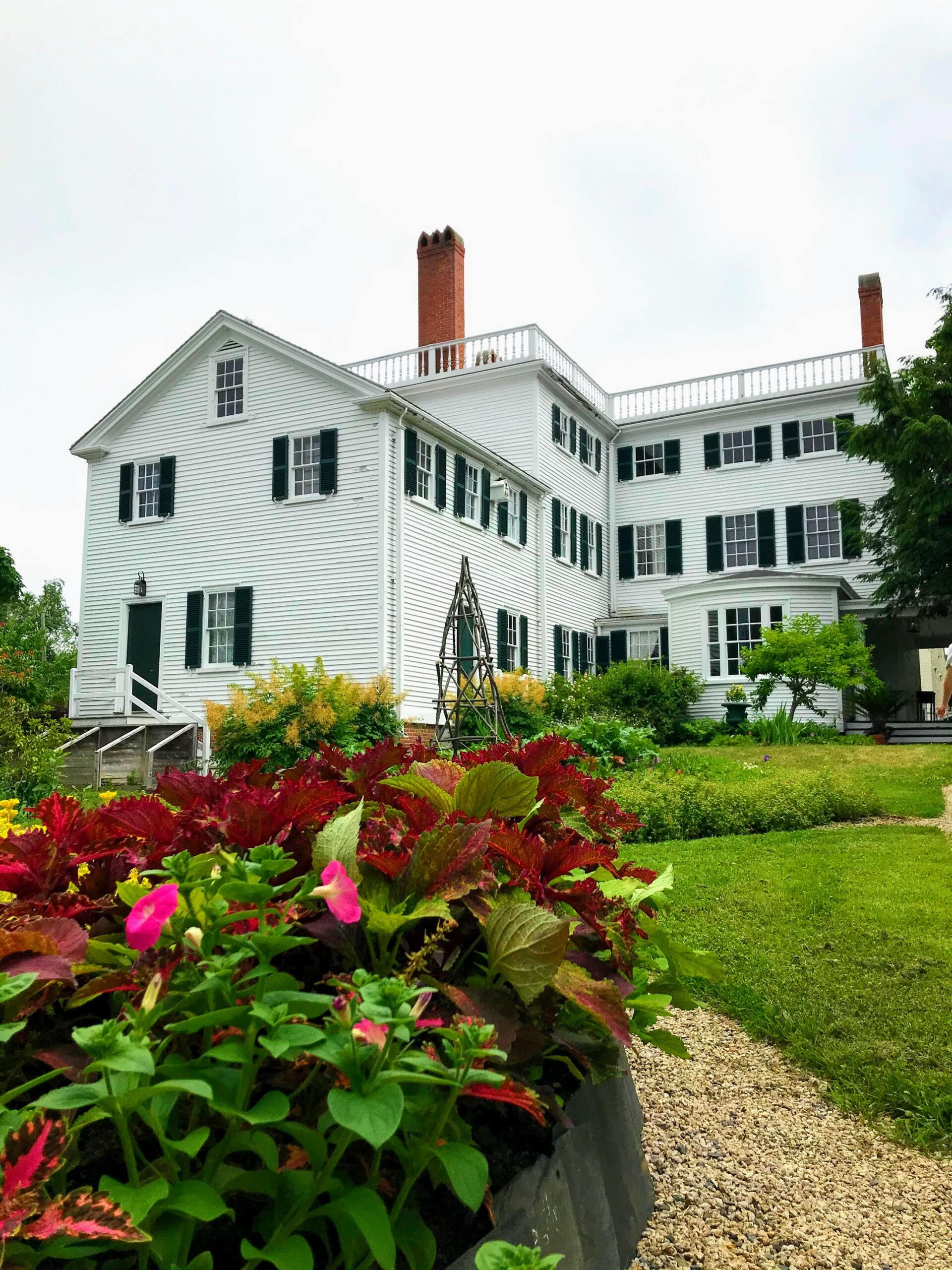 A large white house with flowers in front of it