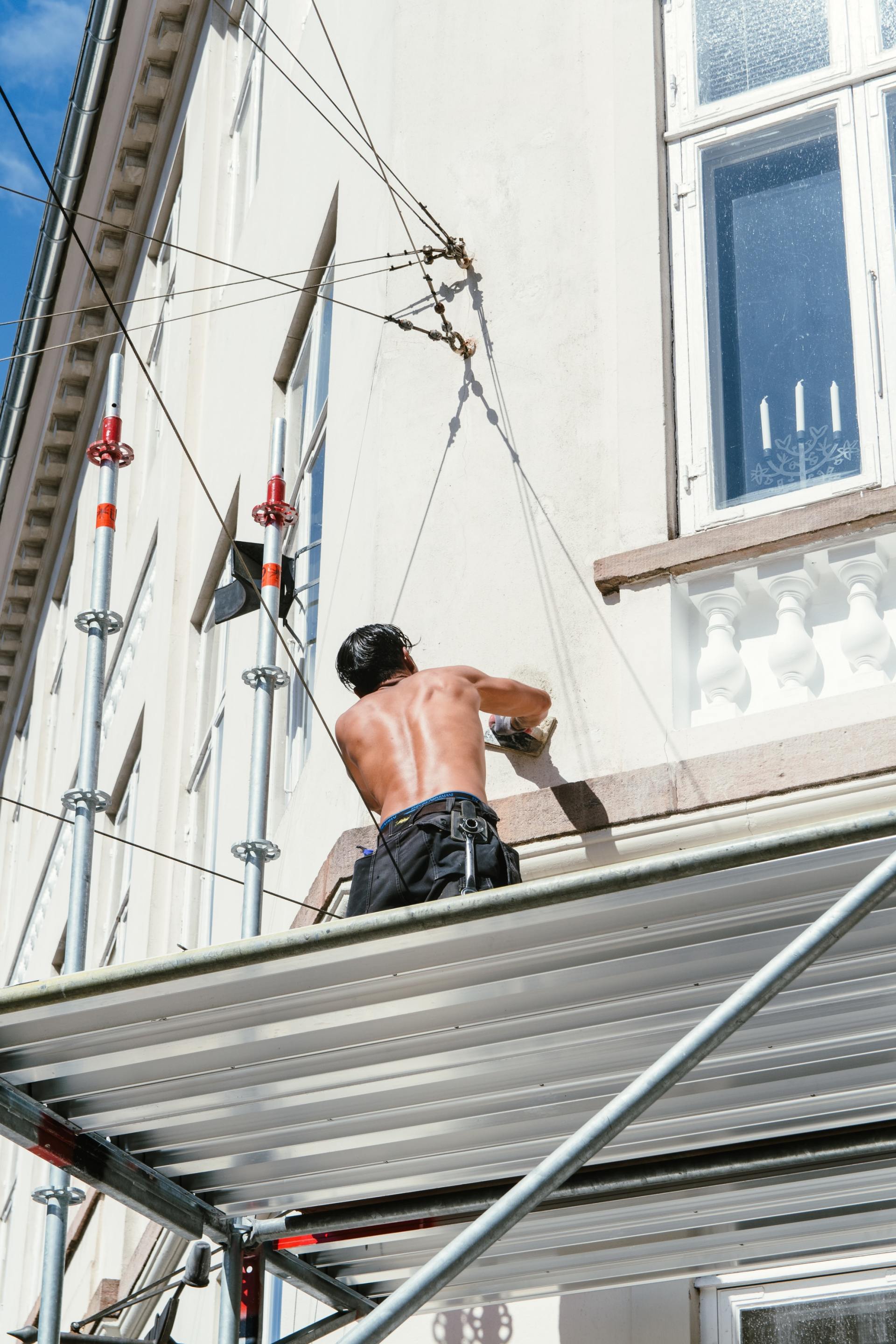 homme repeignant une façade