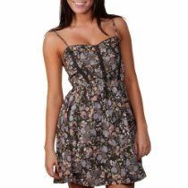 Woman in a floral sundress with thin straps and sweetheart neckline, standing against a white background