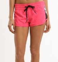 Person wearing bright pink drawstring shorts against a white background
