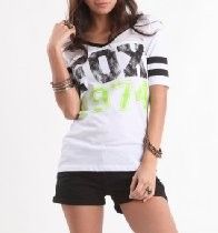 Woman in a white graphic T-shirt and black shorts posing against a white background