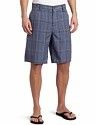 Man wearing blue plaid shorts and black sandals on a white background