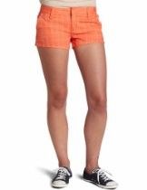 Person wearing orange shorts and black sneakers against a white background