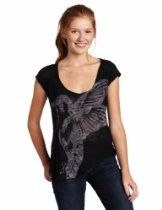 Woman in a black T-shirt with a gray graphic, standing against a white background and smiling.