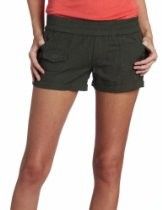 Person wearing dark green shorts and a coral top, standing against a white background