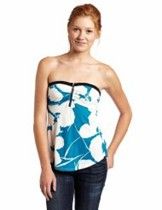 Woman in a strapless blue-and-white floral top and jeans on a white background