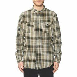 Man wearing a beige plaid button-up shirt with chest pockets, standing against a white background