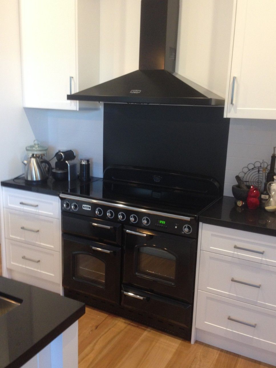 A Kitchen With Black Appliances and White Cabinets — High Kraft Kitchens and Joinery in Berkeley, NSW