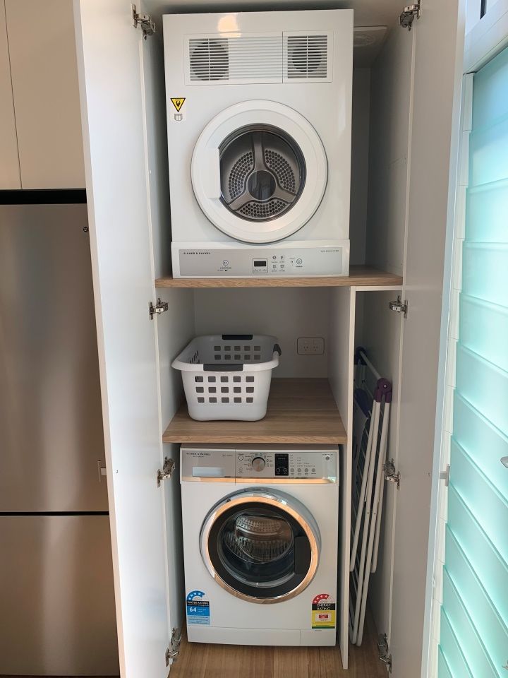 A Washer and Dryer Are Stacked on Top of Each Other in a Cabinet — High Kraft Kitchens and Joinery in Berkeley, NSW