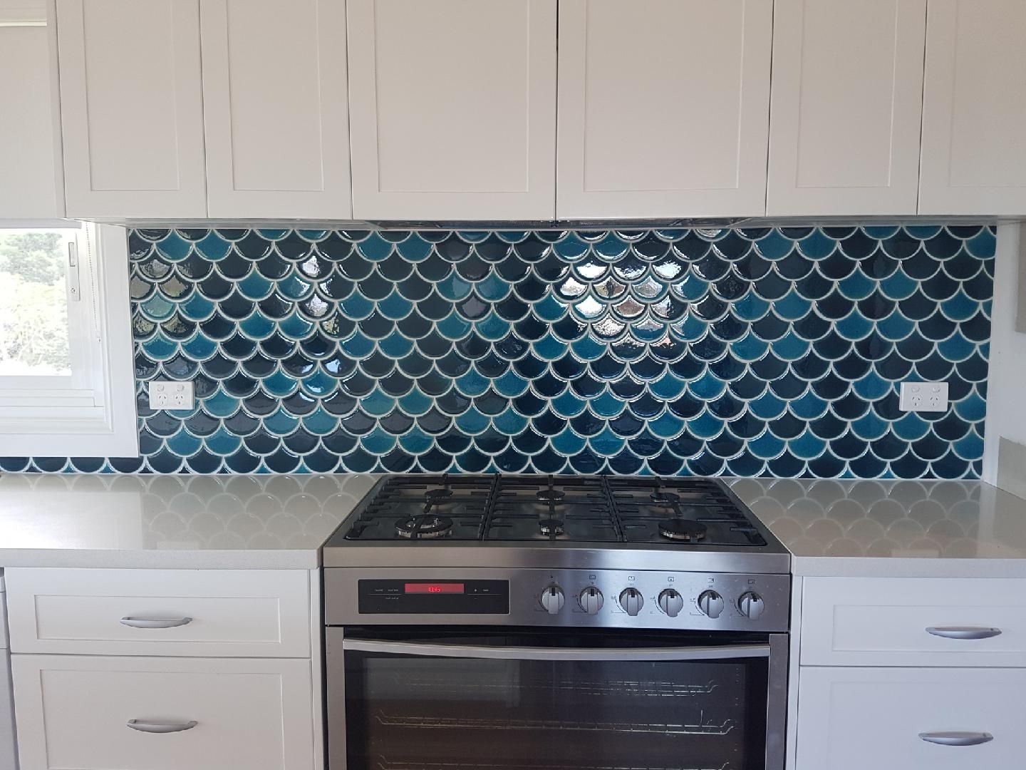 A Kitchen With a Stove, Oven, and Mermaid Tiles on the Wall — High Kraft Kitchens and Joinery in Berkeley, NSW