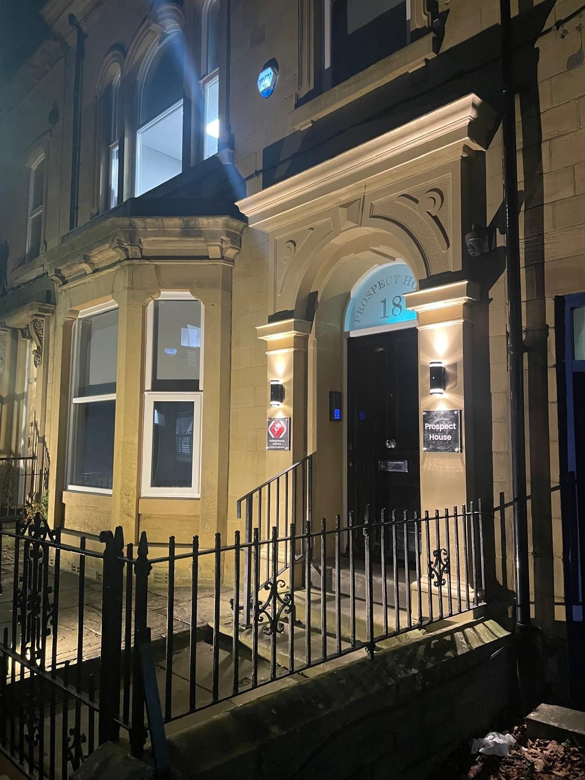 The front of a building is lit up at night.