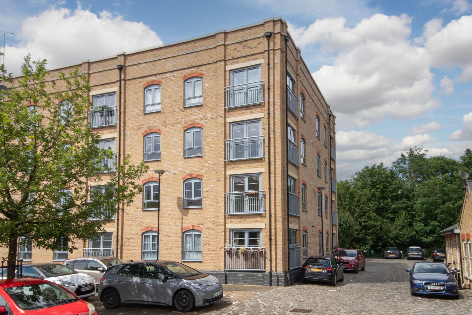 A large brick building with cars parked in front of it.