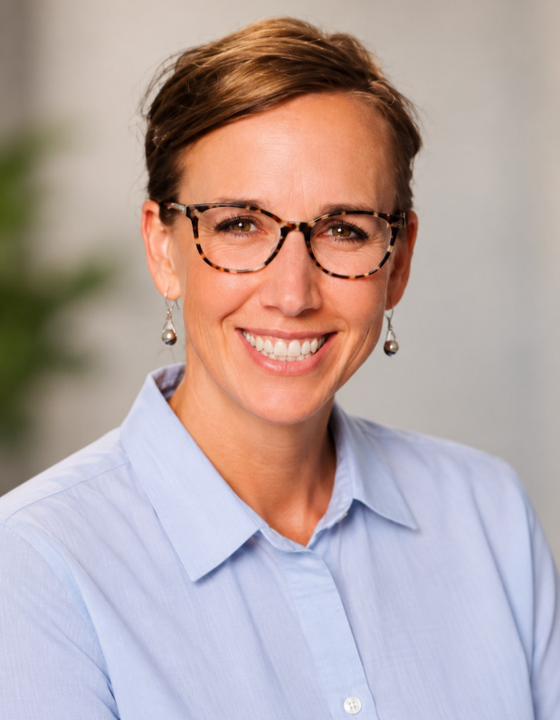 Smiling medical professional in a white coat standing in a clinic office