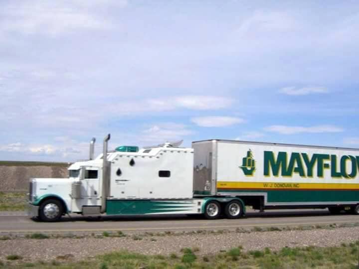 White Mayflower moving truck parked on a road under a cloudy sky